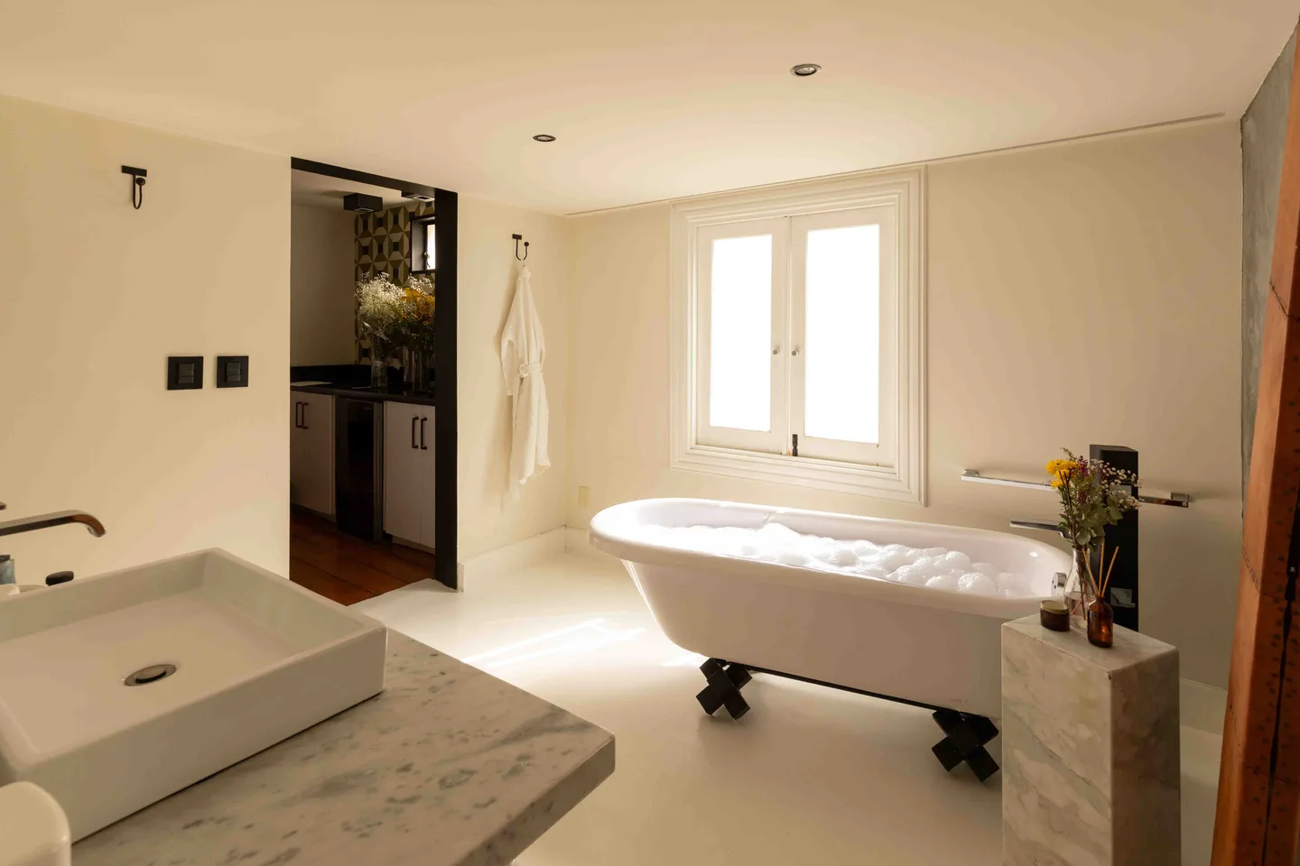 Bright bathroom with clawfoot bathtub and stone basin — Polaris Suite, La Valise Mexico City