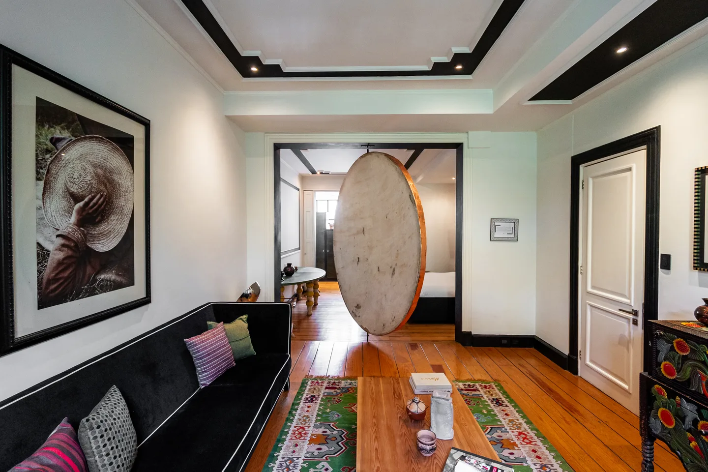 Living room with velvet sofa looking toward the oscillating Moon installation — Moon Suite, La Valise Mexico City
