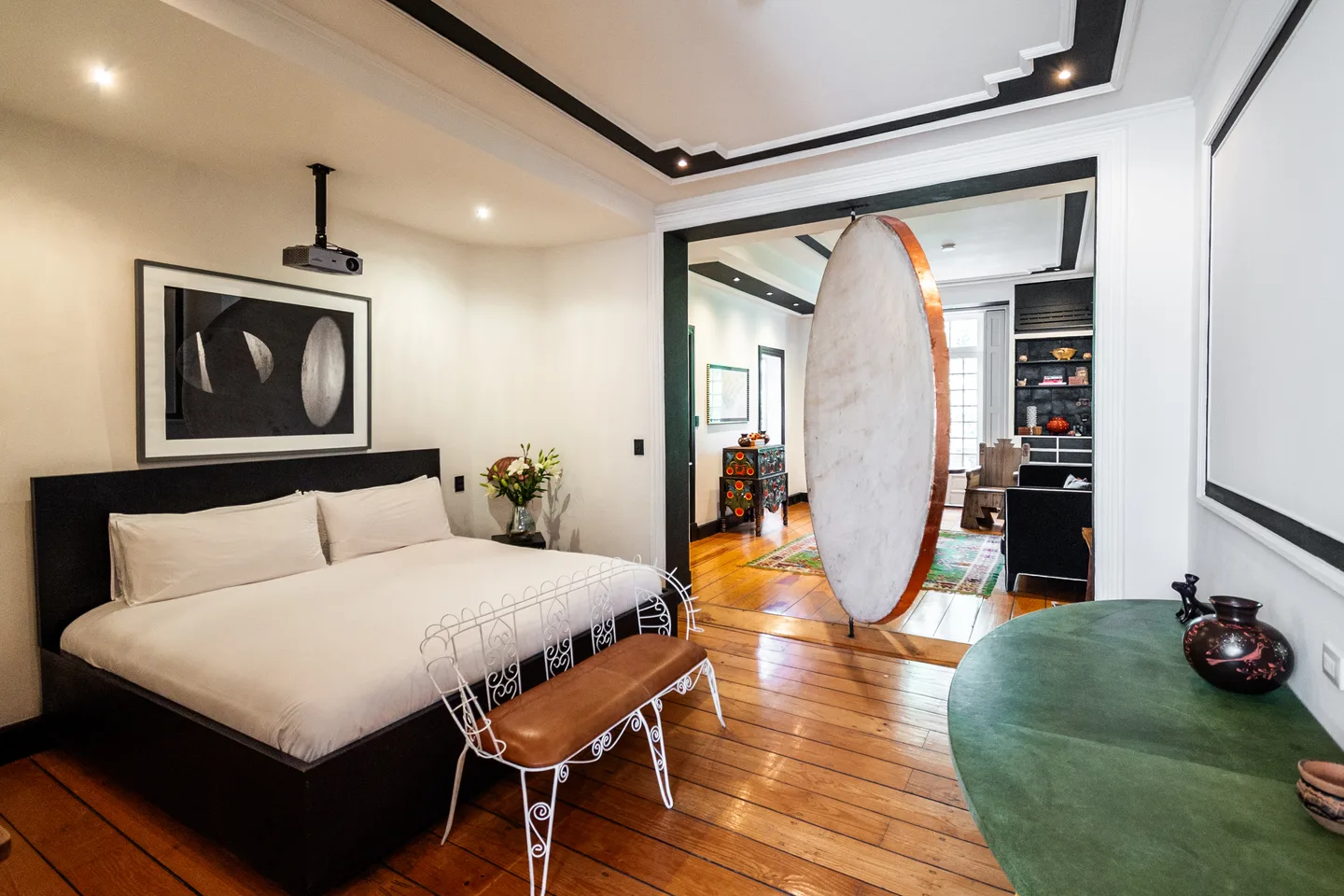 Bedroom with the pivoting Moon disc installation opening to the living room — Moon Suite, La Valise Mexico City