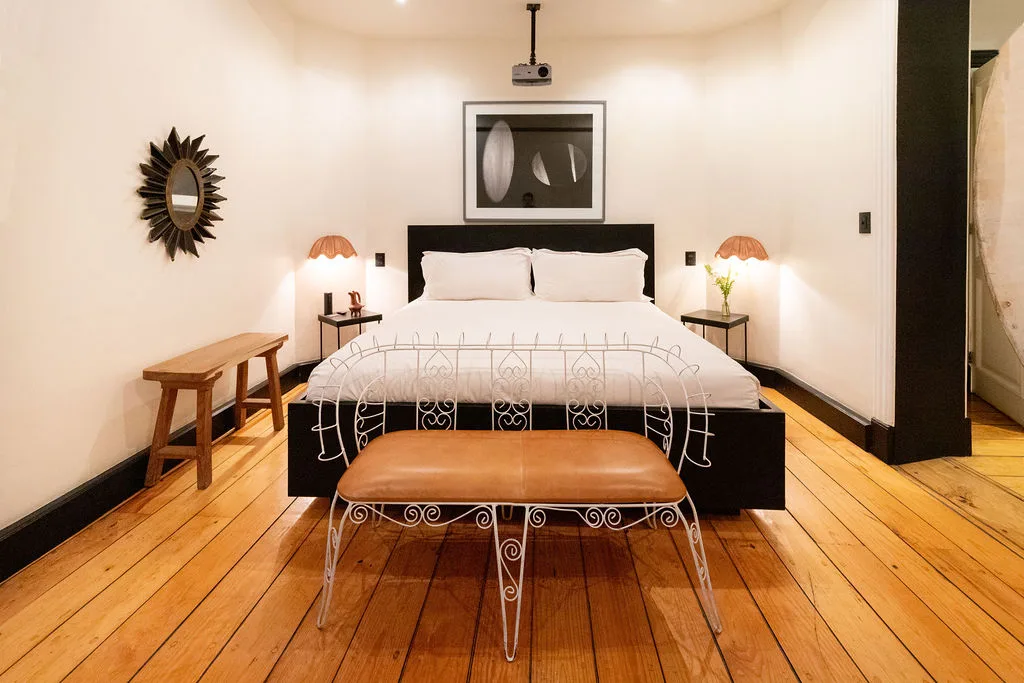 King-size bed with leather bench and sunburst mirror — Moon Suite, La Valise Mexico City