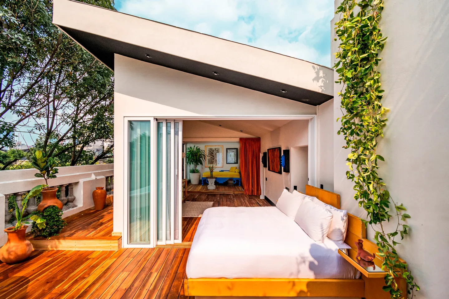 Rolling bed glided out onto the wooden terrace framed by climbing vines — Cilene Suite, La Valise Mexico City