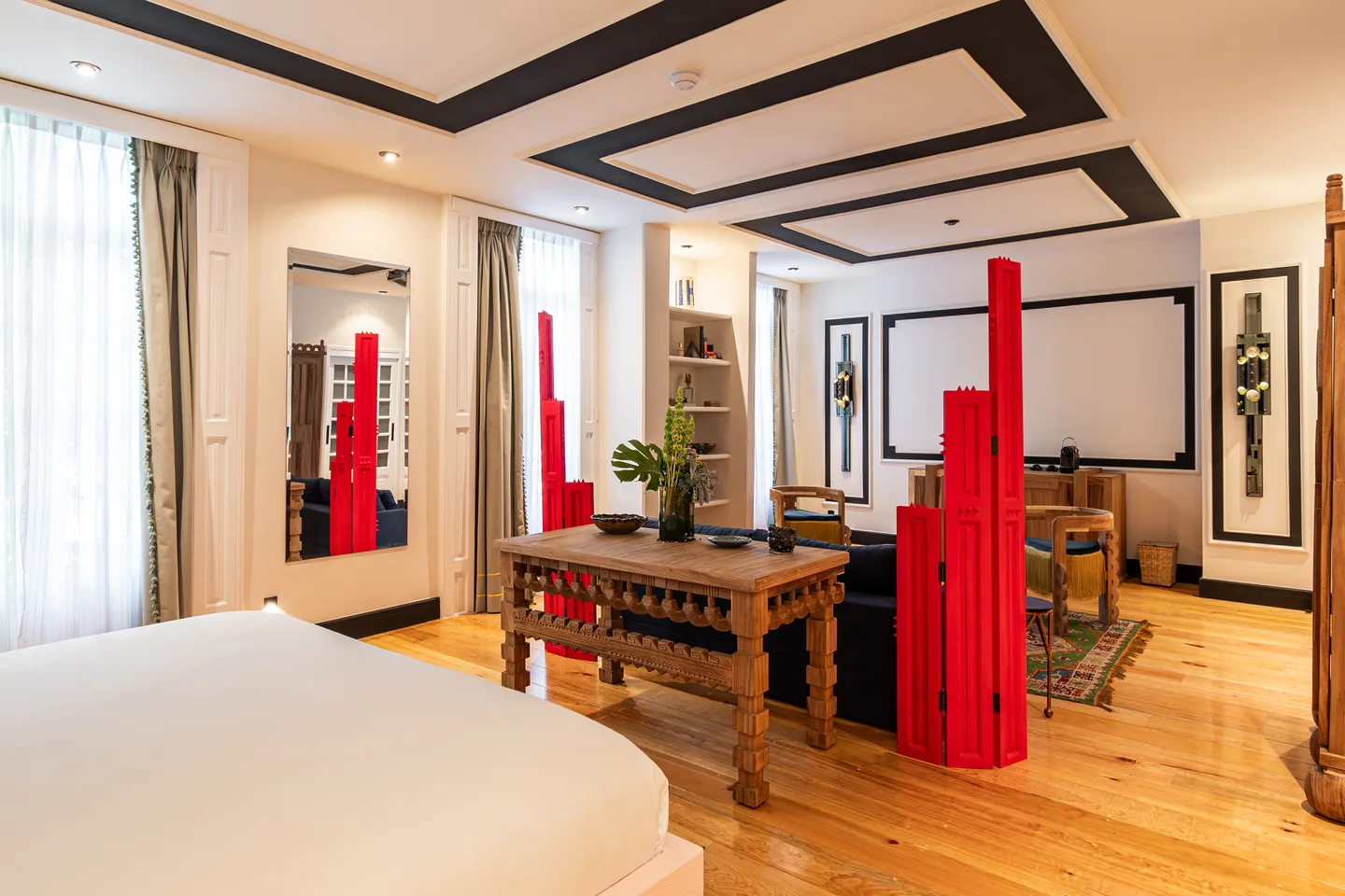 View from the bed toward the writing table and red sculptures — Halo Suite, La Valise Mexico City