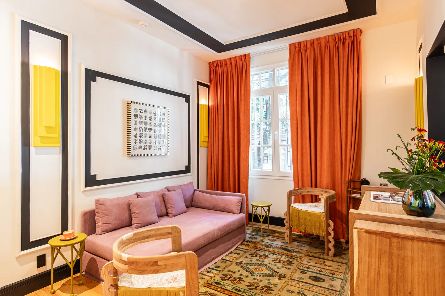 Seating area with a pink sofa and orange curtains — Nebula Suite, La Valise Mexico City