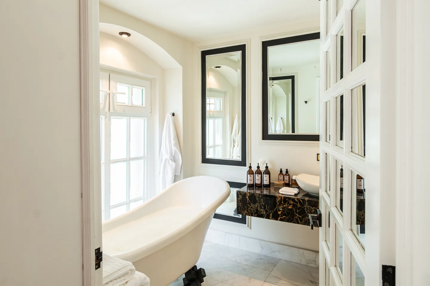 Freestanding bathtub glimpsed through the bathroom doors — Nebula Suite, La Valise Mexico City