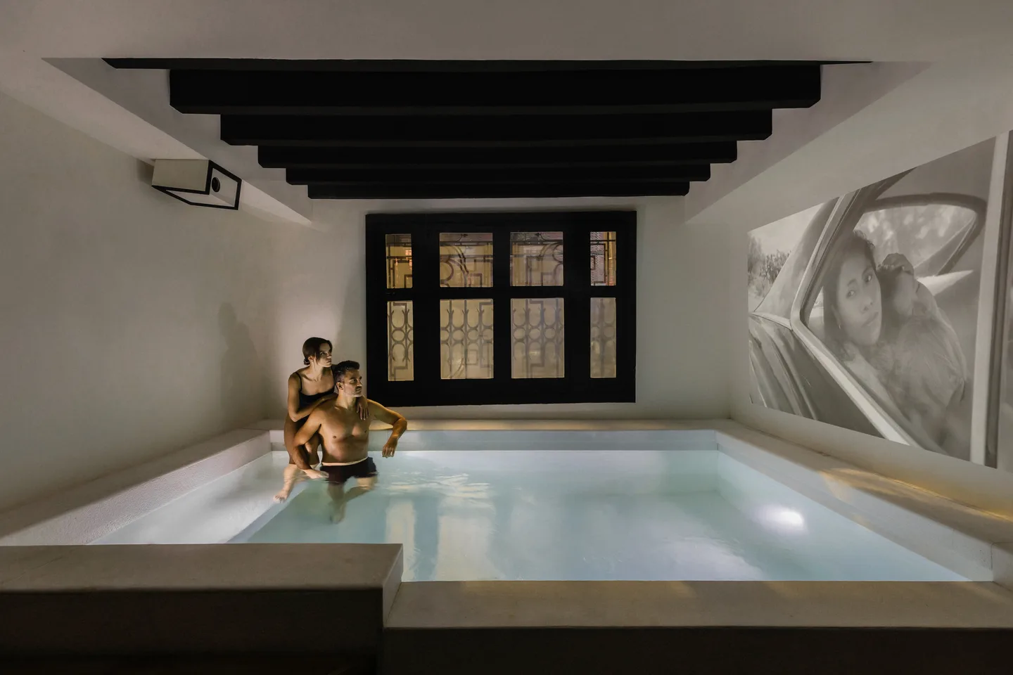 Couple relaxing in the illuminated indoor pool of the Pis-cinema at La Valise Mexico City