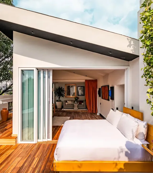 Suite with a rolling bed on a wooden terrace and forest views at La Valise Mexico City Hotel.