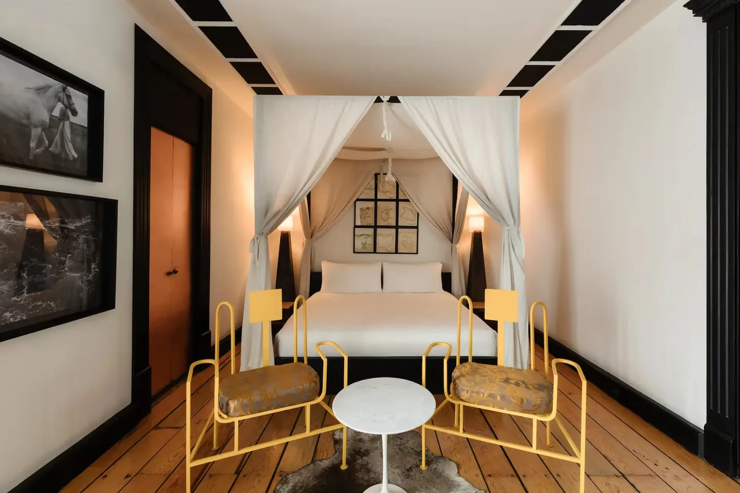 Elegant canopy bed with white drapes in a luxury suite at La Valise Mexico City Hotel.