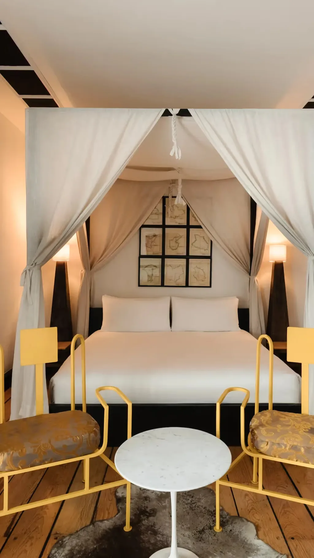 Elegant canopy bed with white drapes in a luxury suite at La Valise Mexico City Hotel.