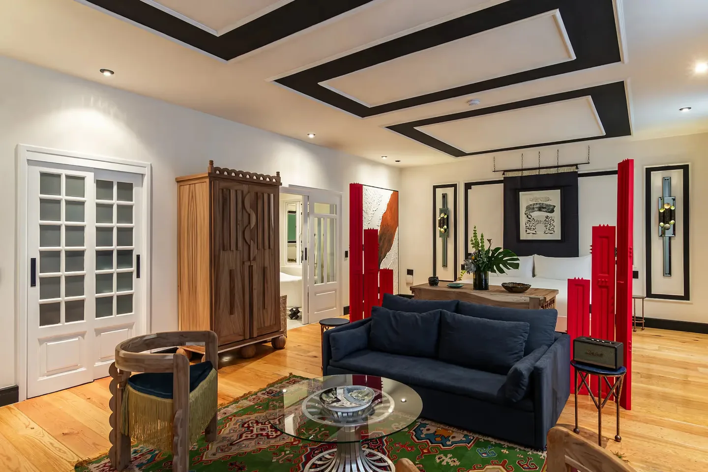 Elegant lounge featuring a blue sofa and red accents at La Valise Mexico City Hotel.