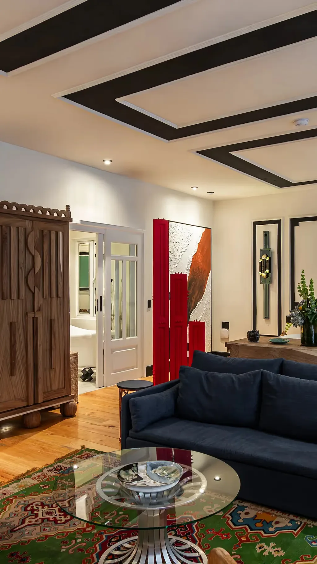 Elegant lounge featuring a blue sofa and red accents at La Valise Mexico City Hotel.