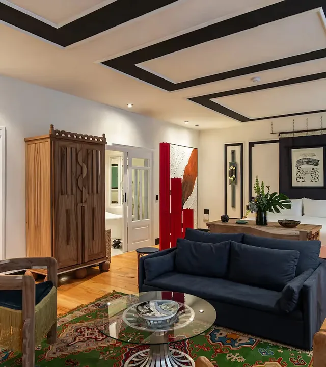Elegant lounge featuring a blue sofa and red accents at La Valise Mexico City Hotel.