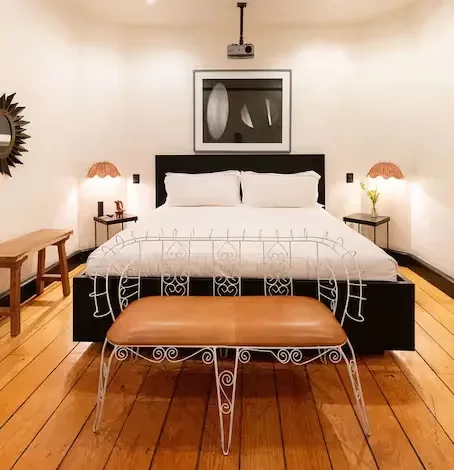 Luxury bedroom featuring wooden floors and a king-size bed at La valise Mexico city hotel.